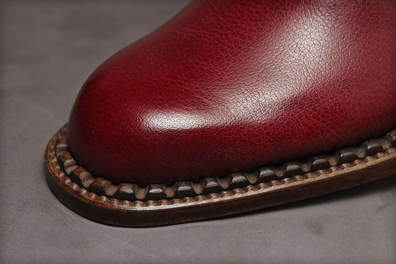 A method for connecting the uppers to the soles that some consider bizarre and others find fascinating. It resembles the pearl method in construction, but the stitching is complimented by a decorative strip of stiff leather that is hand-notched and polished. The provenance of this method is not precisely known, but our prewar employees encountered it in France.